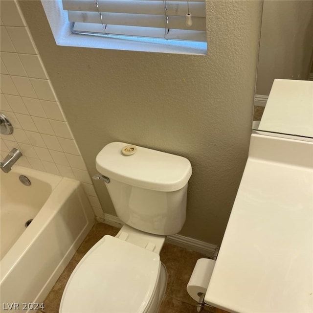 full bathroom featuring vanity, tiled shower / bath combo, toilet, and tile patterned flooring