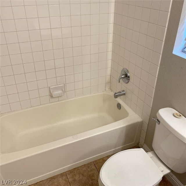 bathroom featuring tiled shower / bath combo, tile patterned floors, and toilet