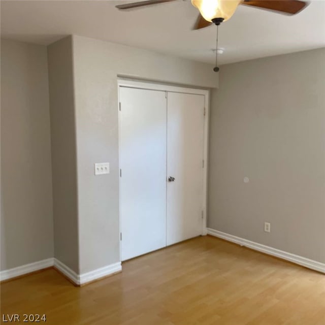 unfurnished bedroom featuring light hardwood / wood-style floors, a closet, and ceiling fan