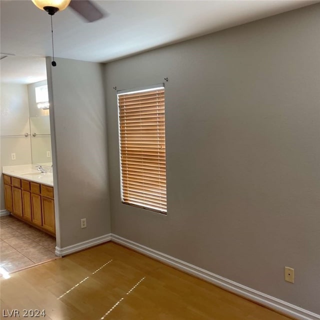 empty room featuring sink, light tile patterned floors, and ceiling fan