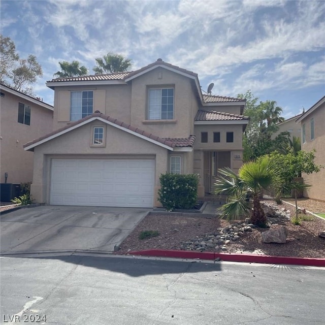 front of property with cooling unit and a garage