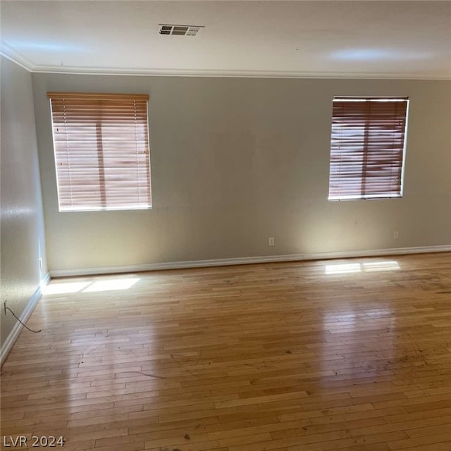 spare room with ornamental molding and wood-type flooring