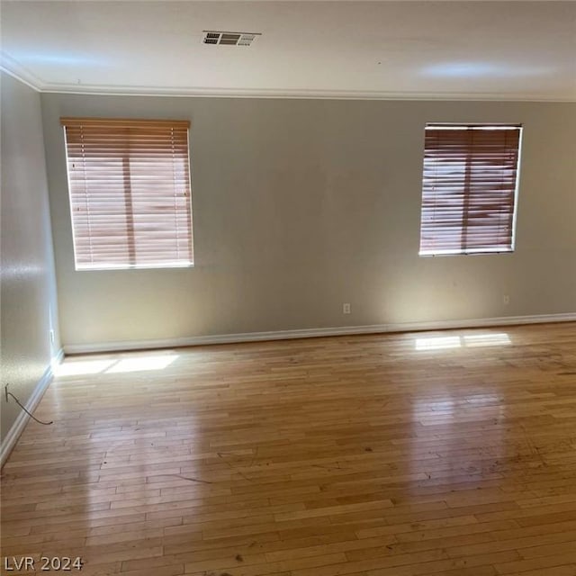 unfurnished room featuring crown molding and hardwood / wood-style floors