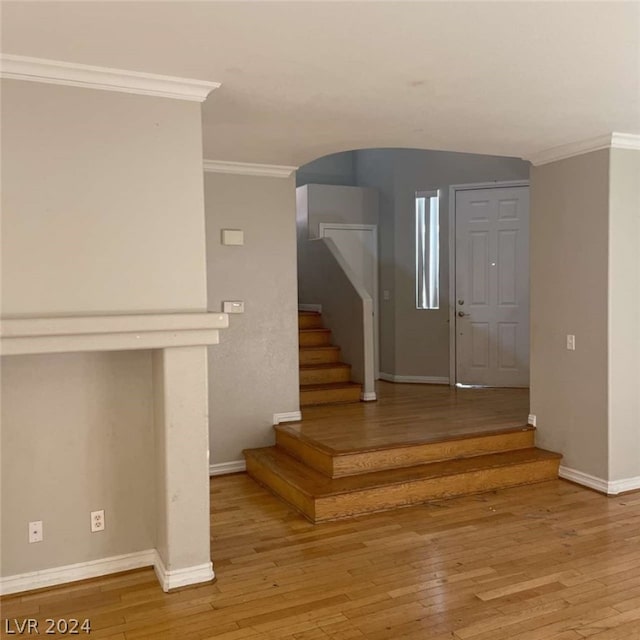 staircase with crown molding and light hardwood / wood-style flooring