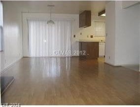 unfurnished living room featuring radiator and hardwood / wood-style floors