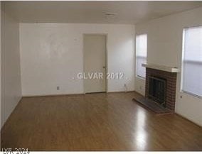 unfurnished living room featuring a wealth of natural light, a fireplace, and hardwood / wood-style floors