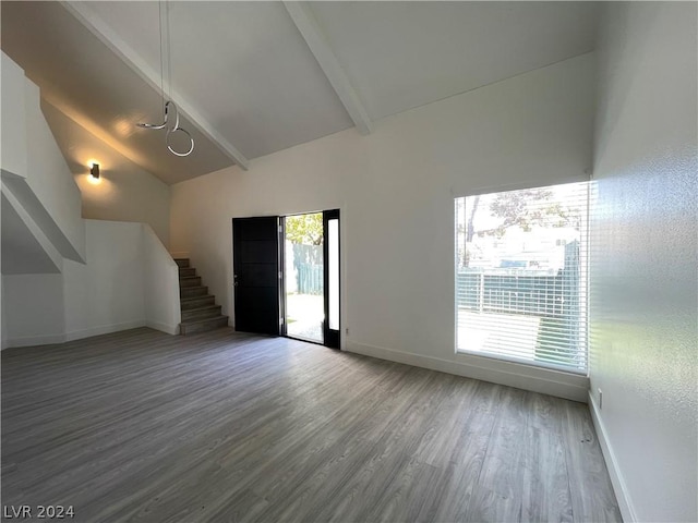 4281 White Sands Ave, Las Vegas, NV 89121 - unfurnished living room featuring beamed ceiling, baseboards, wood finished floors, high vaulted ceiling, and stairway