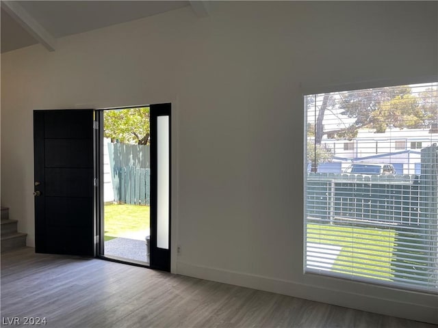 foyer entrance featuring hardwood / wood-style floors and vaulted ceiling with beams