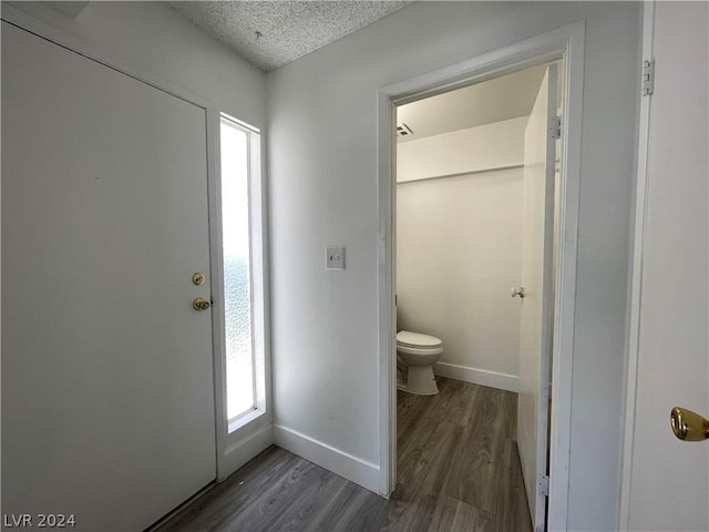 bathroom featuring hardwood / wood-style flooring, toilet, and a textured ceiling