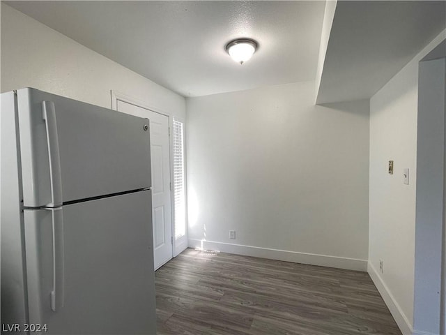 kitchen with white refrigerator and dark wood-type flooring