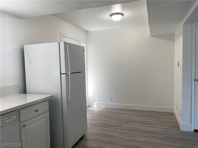 kitchen featuring dark hardwood / wood-style flooring, white cabinets, and white refrigerator