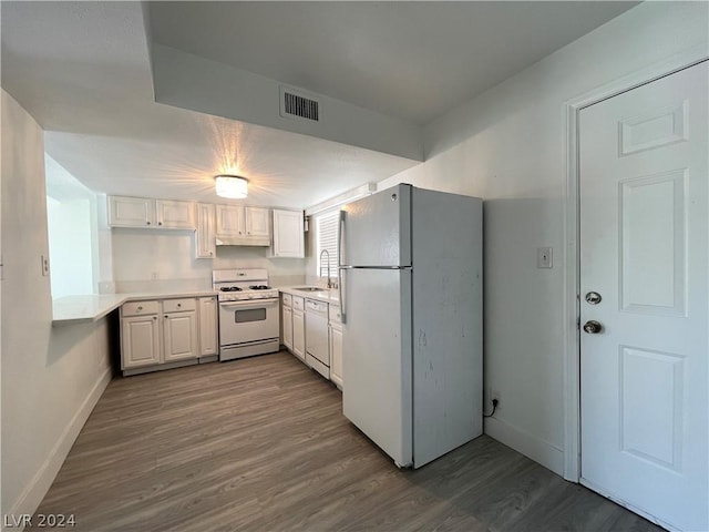 kitchen featuring dark hardwood / wood-style floors, sink, white cabinets, and white appliances