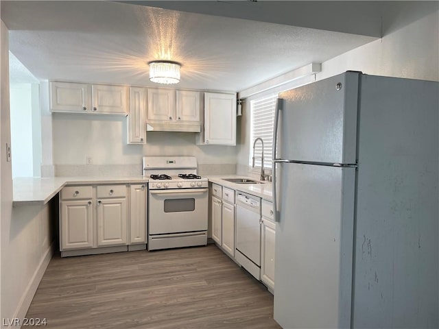 4281 White Sands Ave, Las Vegas, NV 89121 - kitchen featuring white appliances, a sink, white cabinets, light countertops, and wood finished floors