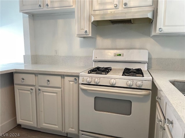 kitchen featuring white range with gas cooktop, light stone countertops, hardwood / wood-style floors, and white cabinets