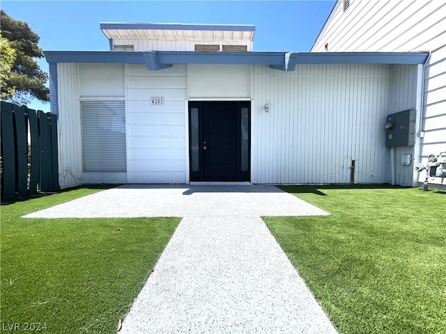 entrance to property featuring a lawn