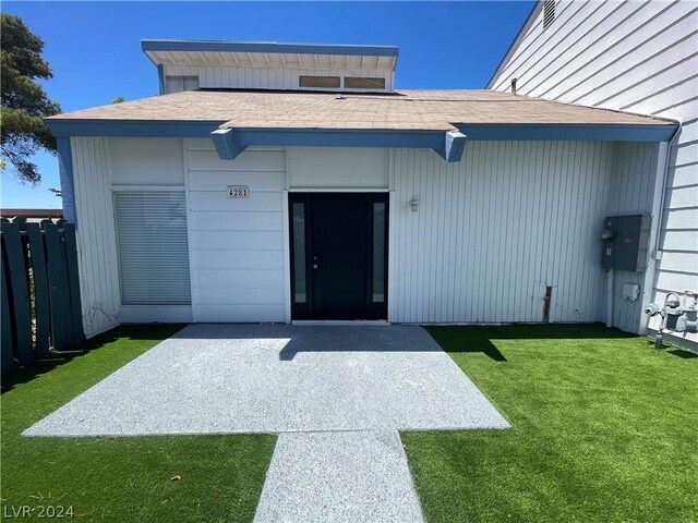 doorway to property featuring a patio and a lawn