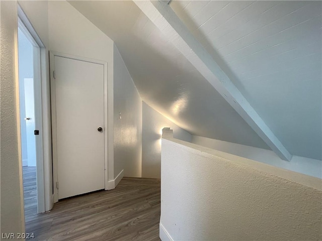 hall featuring hardwood / wood-style flooring and vaulted ceiling with beams