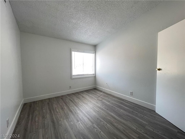 unfurnished room with dark hardwood / wood-style floors and a textured ceiling