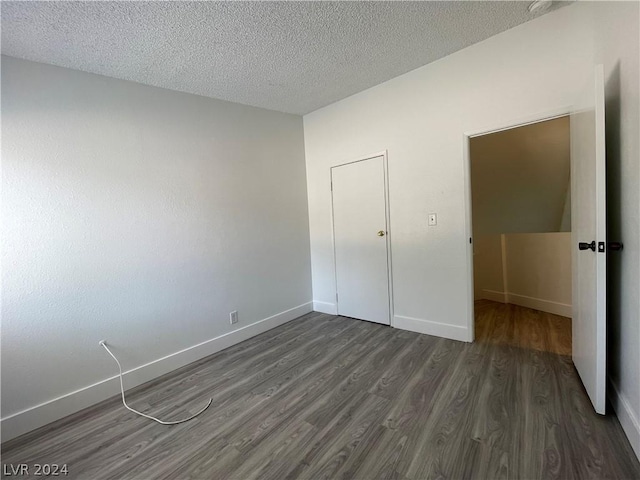 unfurnished bedroom featuring dark wood-type flooring and a textured ceiling