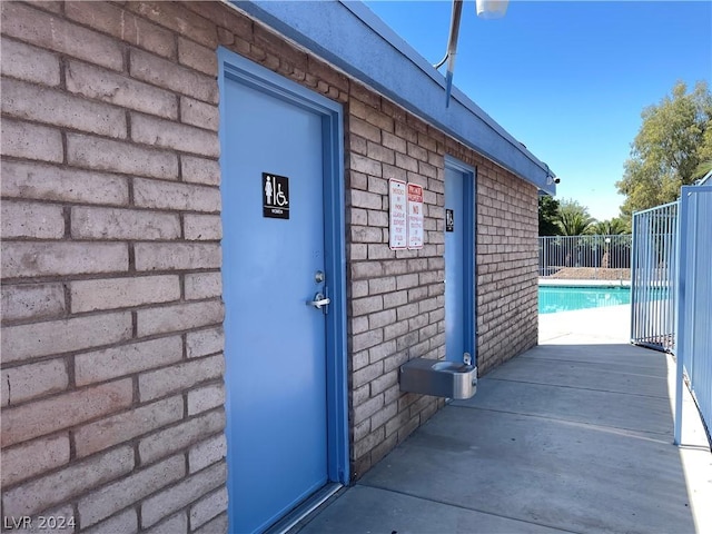 doorway to property featuring a fenced in pool and a patio area