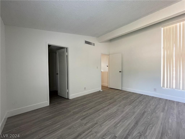 unfurnished bedroom with dark hardwood / wood-style floors and a textured ceiling