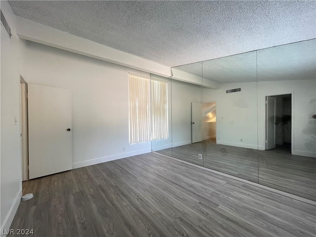 spare room with hardwood / wood-style flooring and a textured ceiling