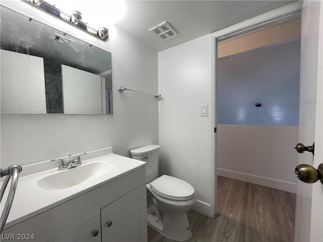 bathroom featuring hardwood / wood-style flooring, vanity, and toilet