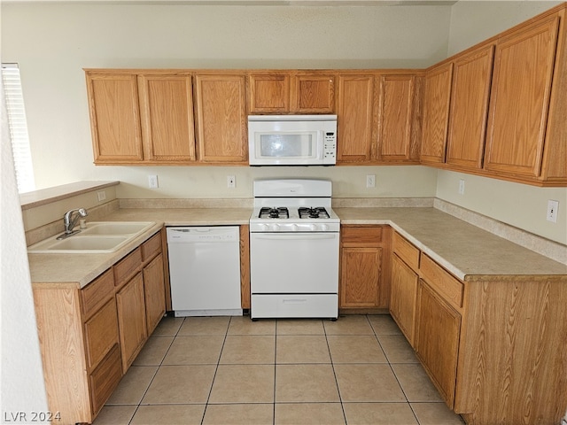 kitchen featuring sink, light tile patterned floors, and white appliances