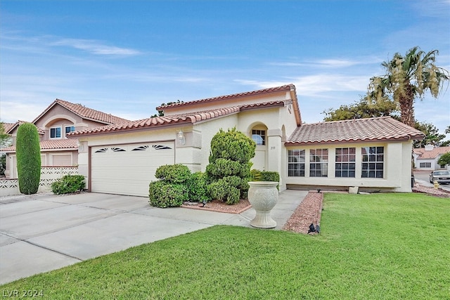 mediterranean / spanish-style house featuring a garage and a front lawn