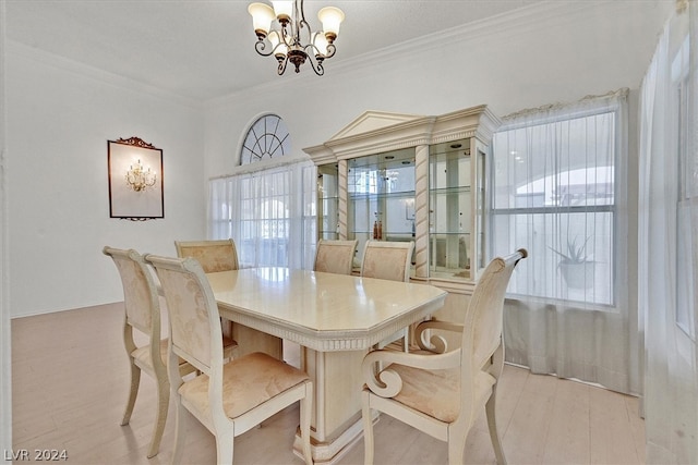 dining area featuring ornamental molding, light hardwood / wood-style flooring, and an inviting chandelier