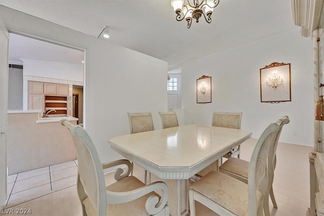 dining area featuring a chandelier, light tile patterned floors, and sink