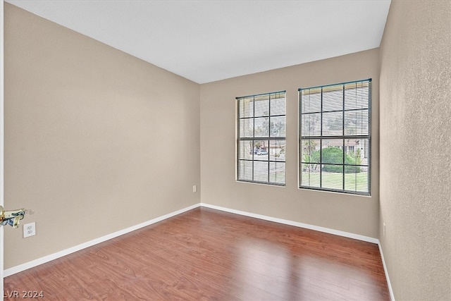 unfurnished room featuring wood-type flooring and a wealth of natural light