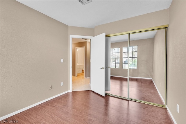 unfurnished bedroom with hardwood / wood-style flooring and a closet