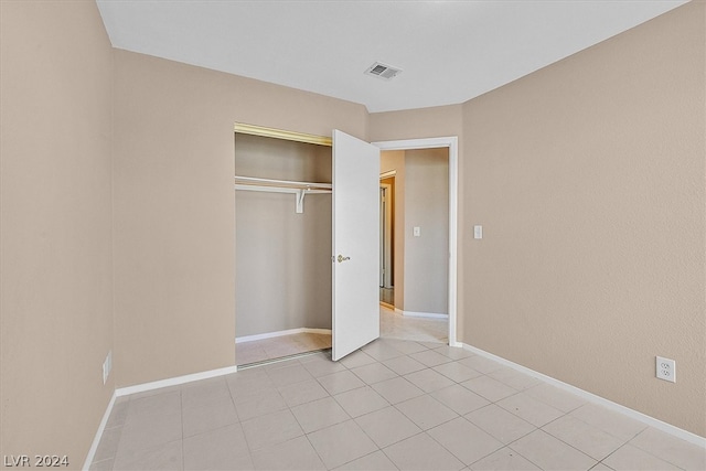 unfurnished bedroom with light tile patterned floors and a closet