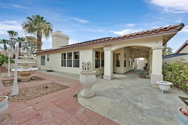 rear view of property featuring ceiling fan and a patio