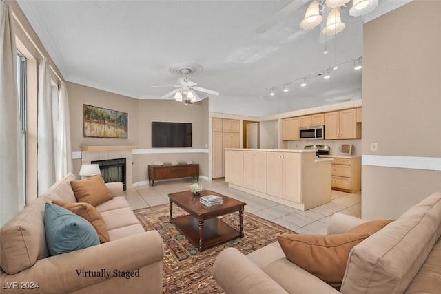 tiled living room featuring ceiling fan, ornamental molding, and a fireplace