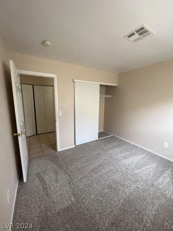 unfurnished bedroom with light carpet and a closet