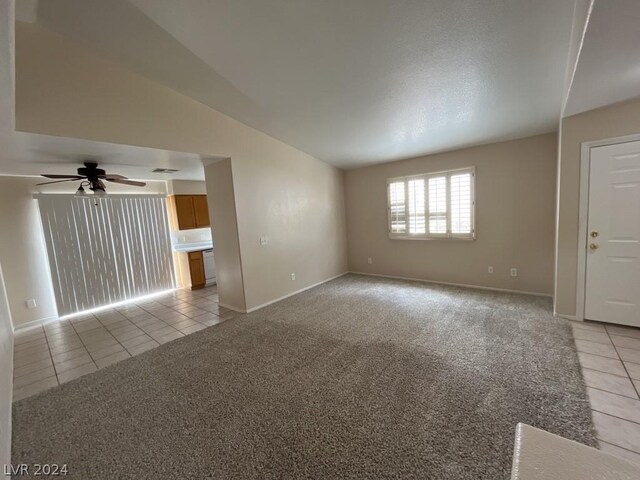 carpeted empty room with ceiling fan and lofted ceiling