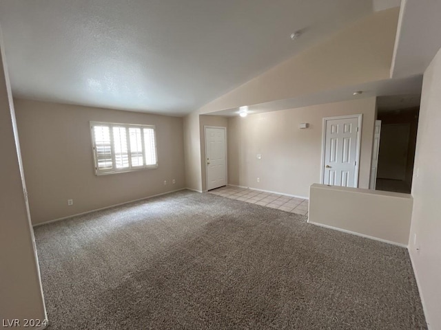 empty room featuring vaulted ceiling and light colored carpet