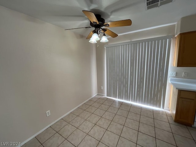 tiled spare room featuring ceiling fan