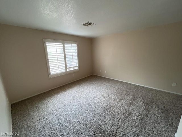 unfurnished room featuring carpet floors and a textured ceiling