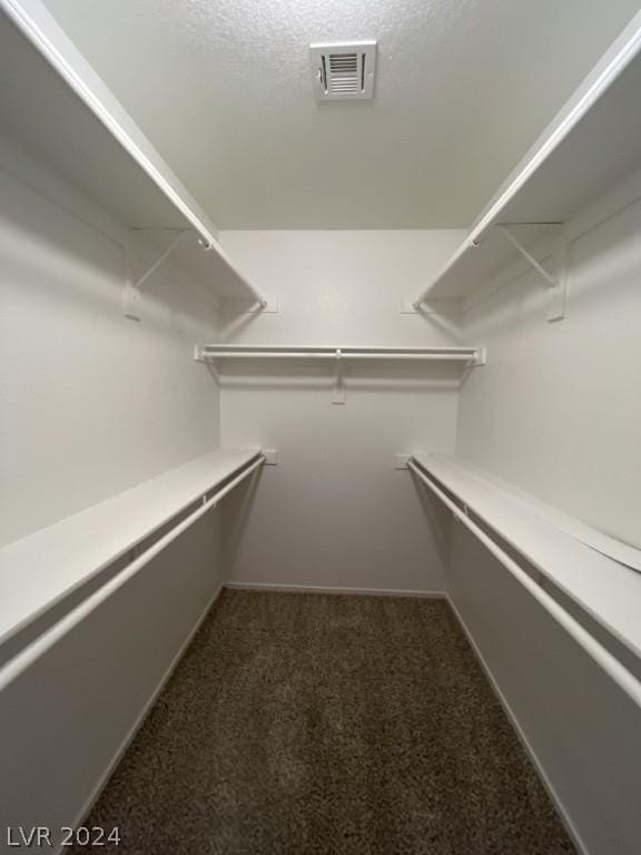 spacious closet featuring dark carpet