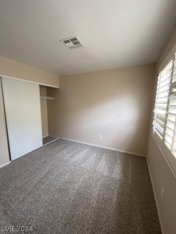 unfurnished bedroom with a closet and carpet