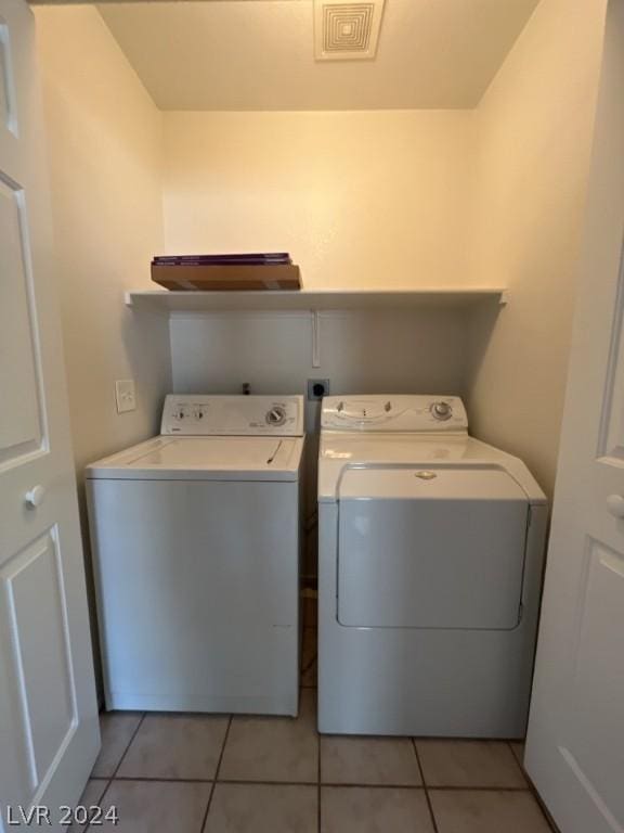 laundry area with washer and dryer and light tile patterned floors