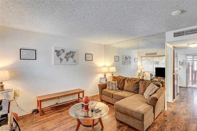 living room with hardwood / wood-style flooring and a textured ceiling