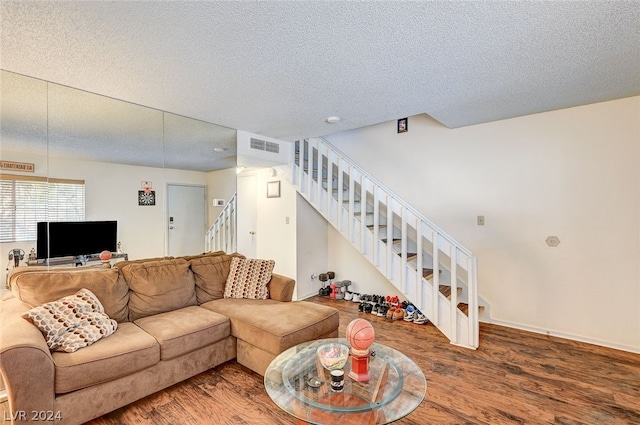 living room featuring a textured ceiling and wood-type flooring