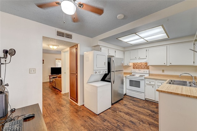 kitchen with stainless steel fridge, dark hardwood / wood-style flooring, sink, and electric stove