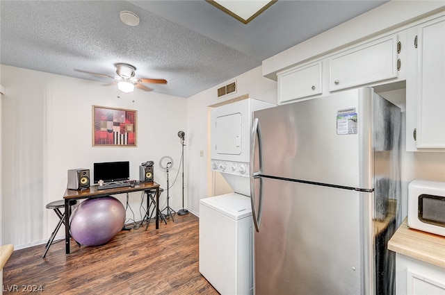 kitchen with stainless steel refrigerator, stacked washing maching and dryer, white cabinets, dark hardwood / wood-style flooring, and ceiling fan