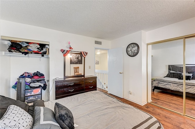 bedroom featuring a textured ceiling, a closet, and wood-type flooring