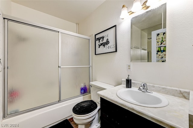 full bathroom featuring vanity, shower / bath combination with glass door, and toilet